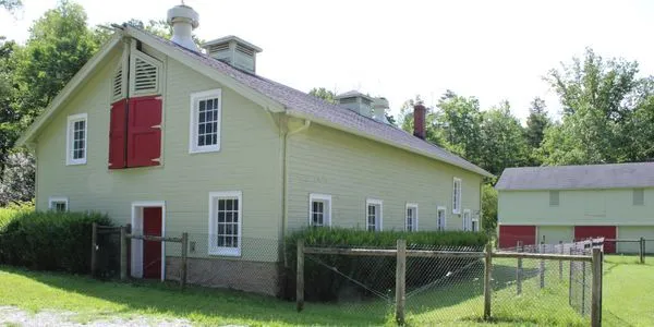 A view across the sanctuary's open grounds and weathered farm buildings.
